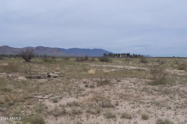a view of mountain with sunset and trees in background