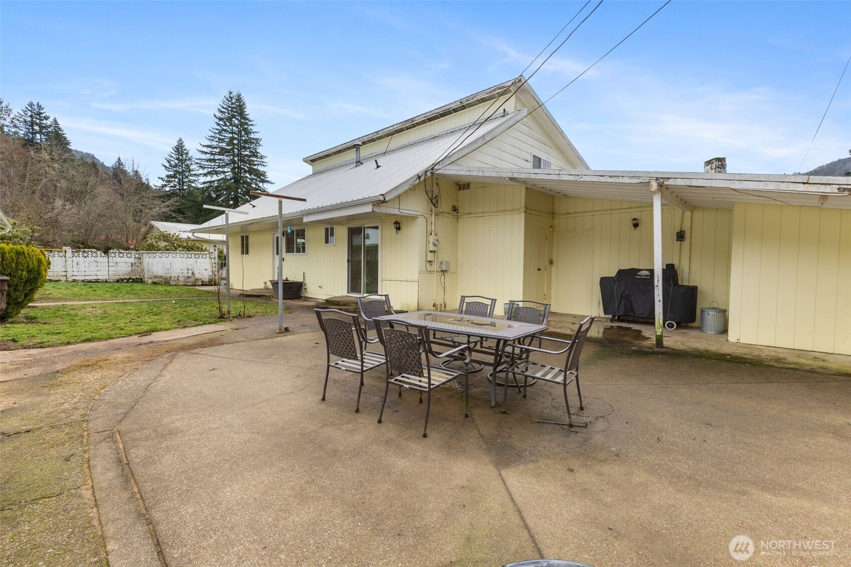 545 Davis Lake Road Morton, WA 98356 - Photo 22 of 32 a view of a patio with table and chairs with wooden fence and plants