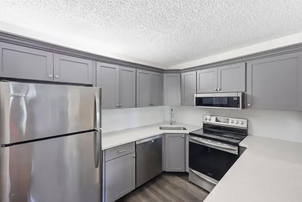 a bathroom with a granite countertop sink a toilet and mirror