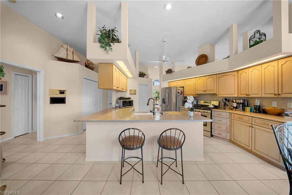 3971 Spring Garden Lane Estero, FL 33928 - Photo 2 of 31 a kitchen with stainless steel appliances granite countertop a sink and a refrigerator