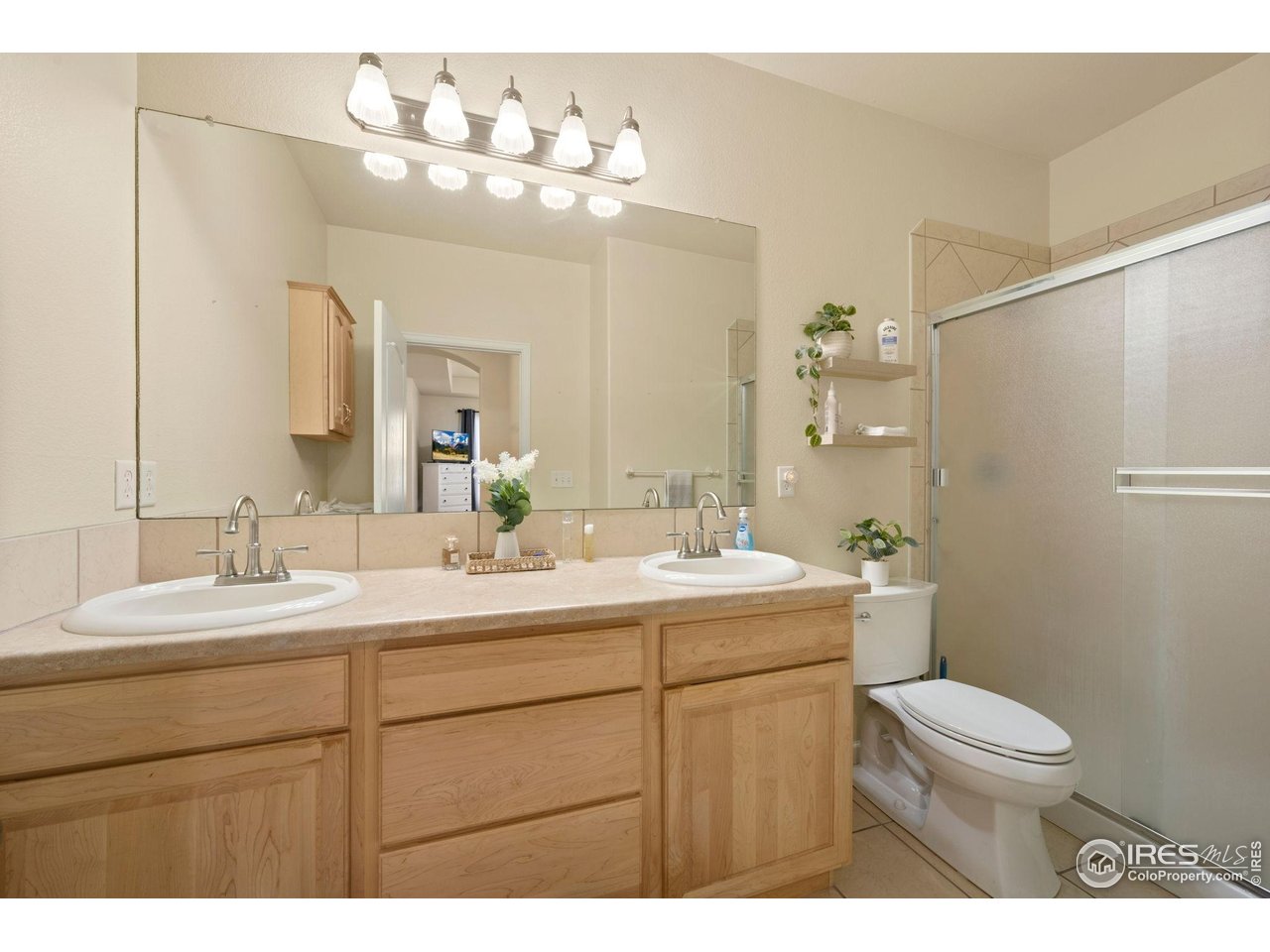 6608 West 3rd Street, Unit 61 Greeley, CO 80634 - Photo 11 of 16 a bathroom with a toilet a sink a large mirror and shower