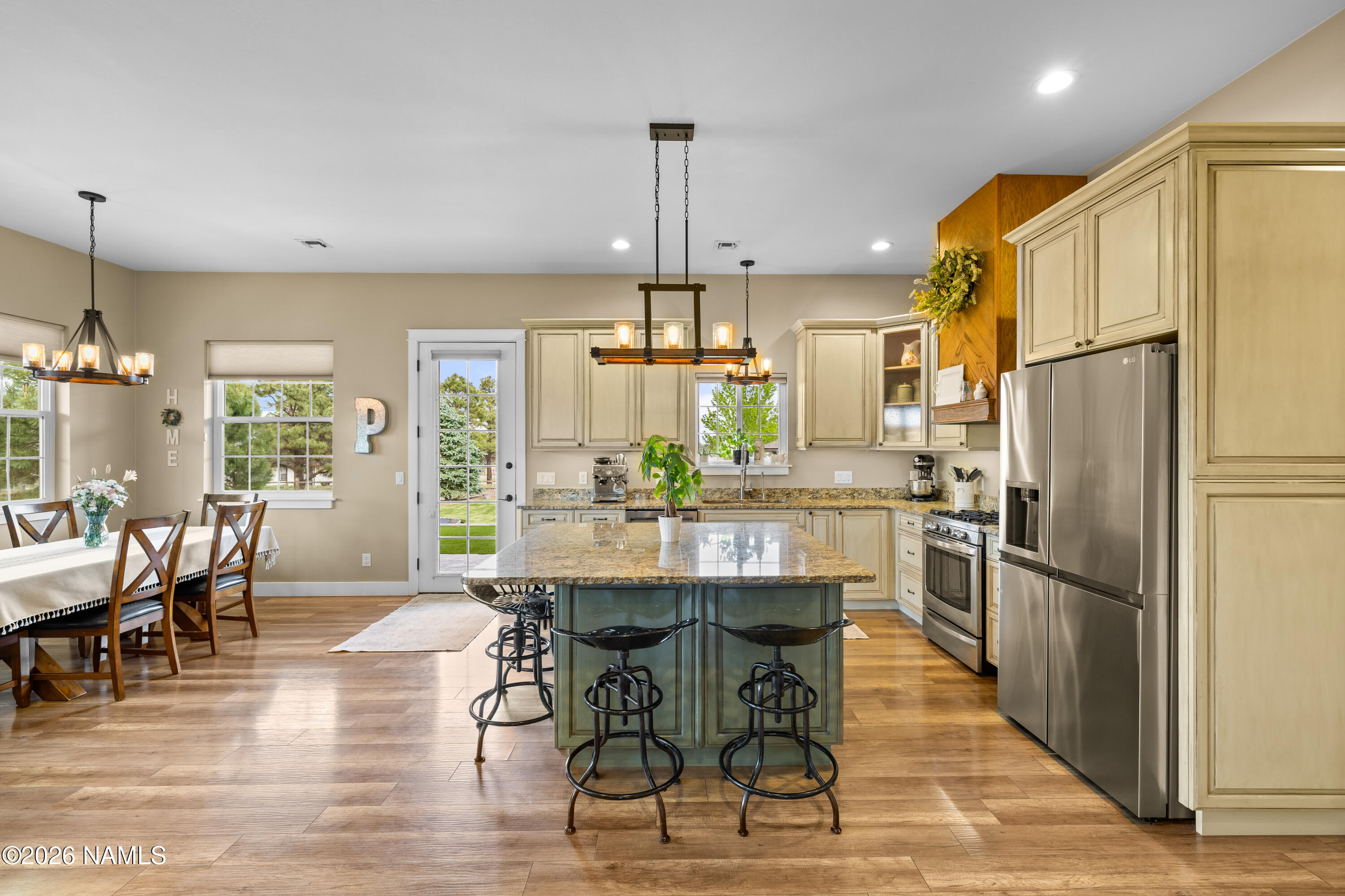 10833 Sage Road Flagstaff, AZ 86004 - Photo 11 of 45 a kitchen with stainless steel appliances a dining table chairs a refrigerator and cabinets