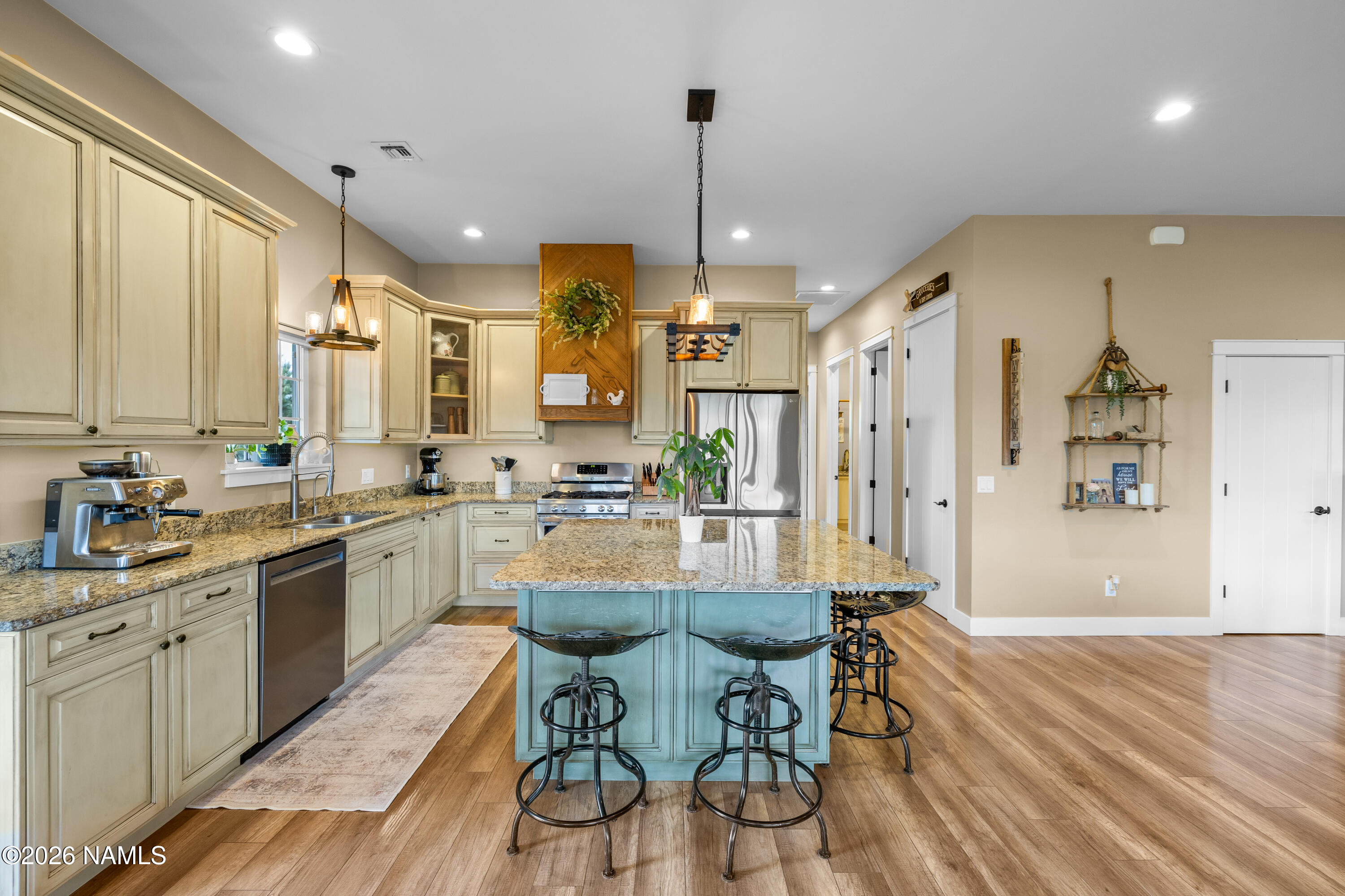 10833 Sage Road Flagstaff, AZ 86004 - Photo 13 of 45 a kitchen with stainless steel appliances kitchen island granite countertop a sink cabinets and wooden floor