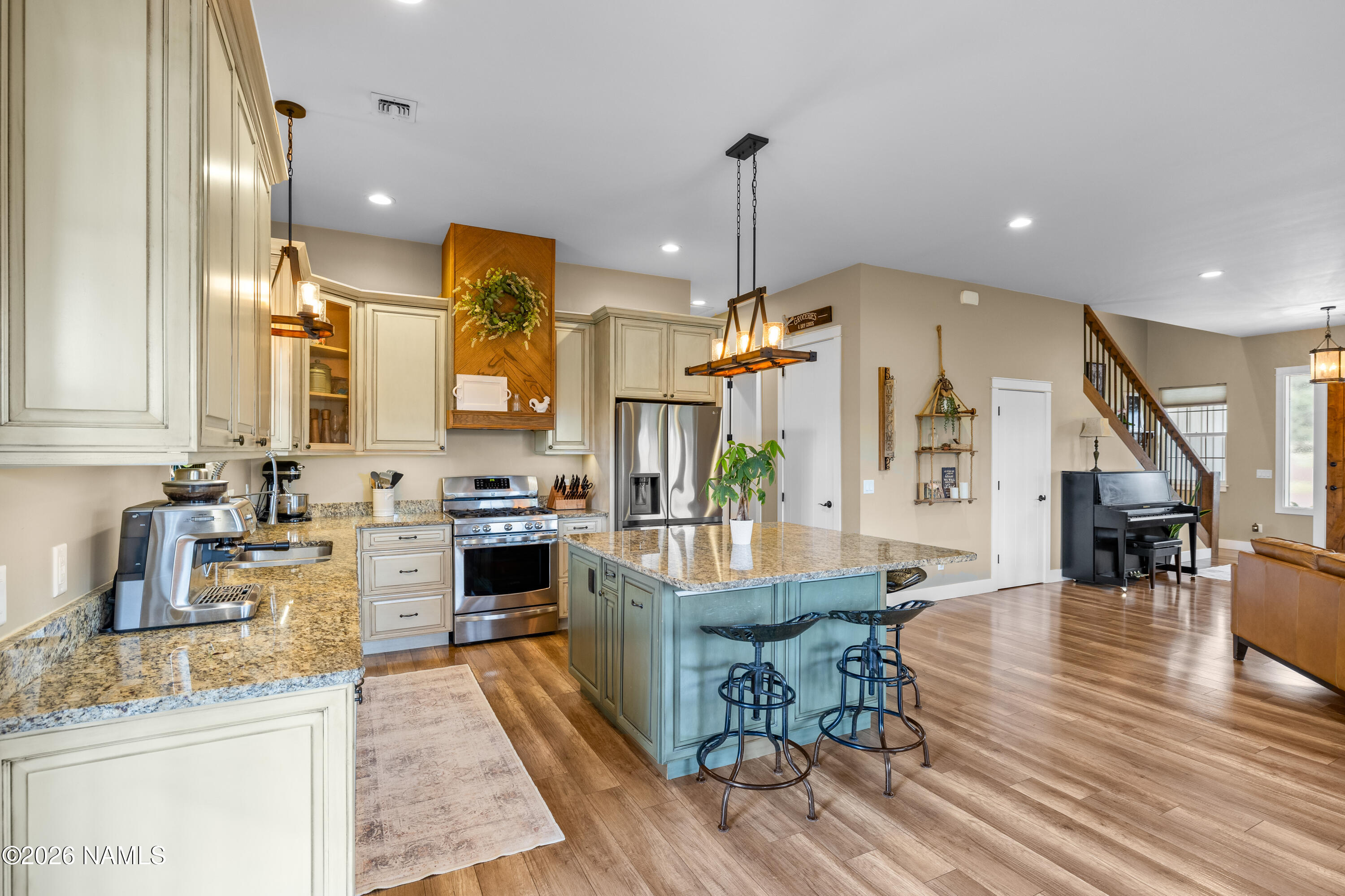 10833 Sage Road Flagstaff, AZ 86004 - Photo 14 of 45 a kitchen with stainless steel appliances kitchen island granite countertop a stove a sink a oven and a dining table with wooden floor