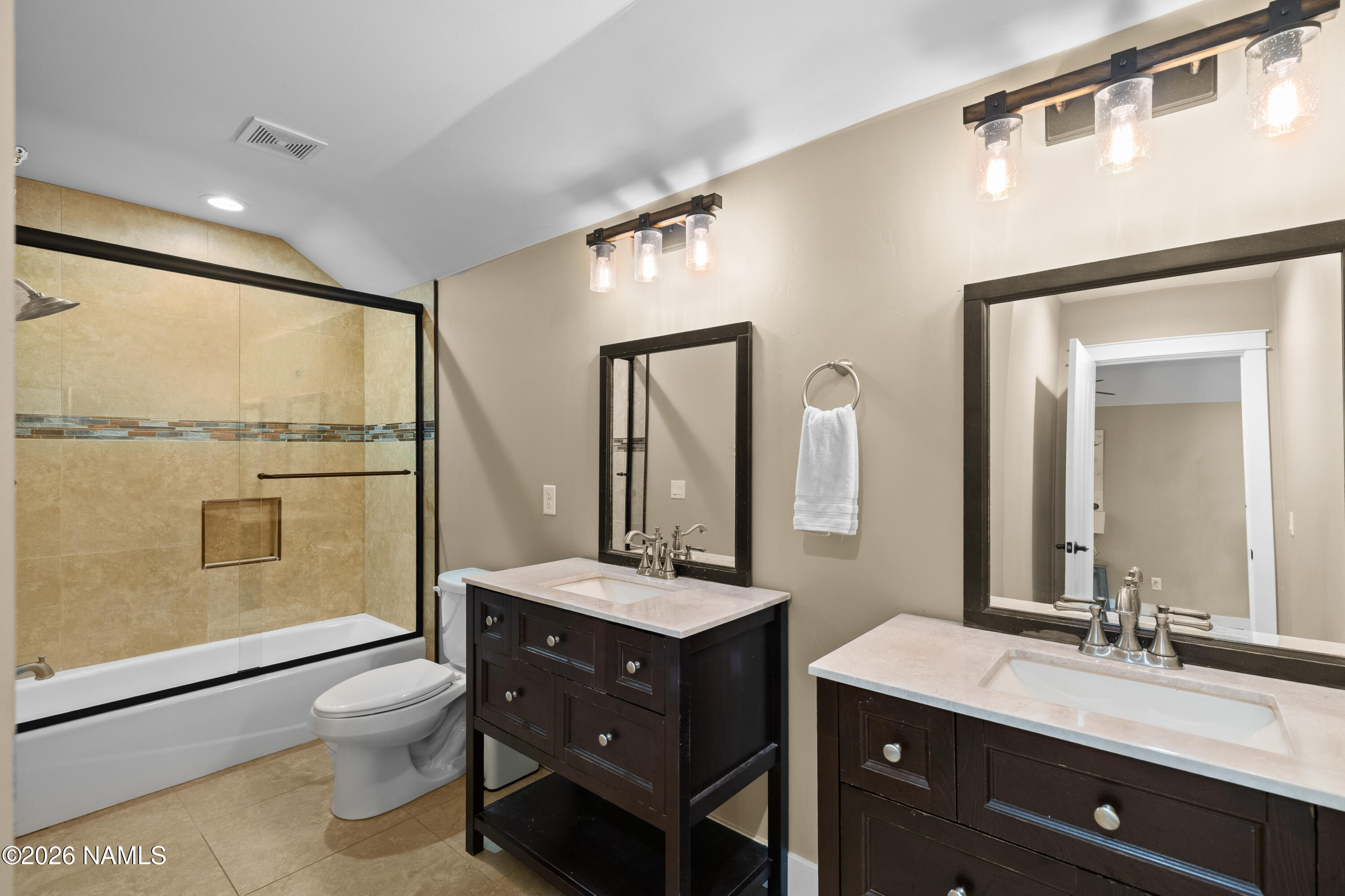 10833 Sage Road Flagstaff, AZ 86004 - Photo 29 of 45 a bathroom with a double vanity sink toilet mirror and shower