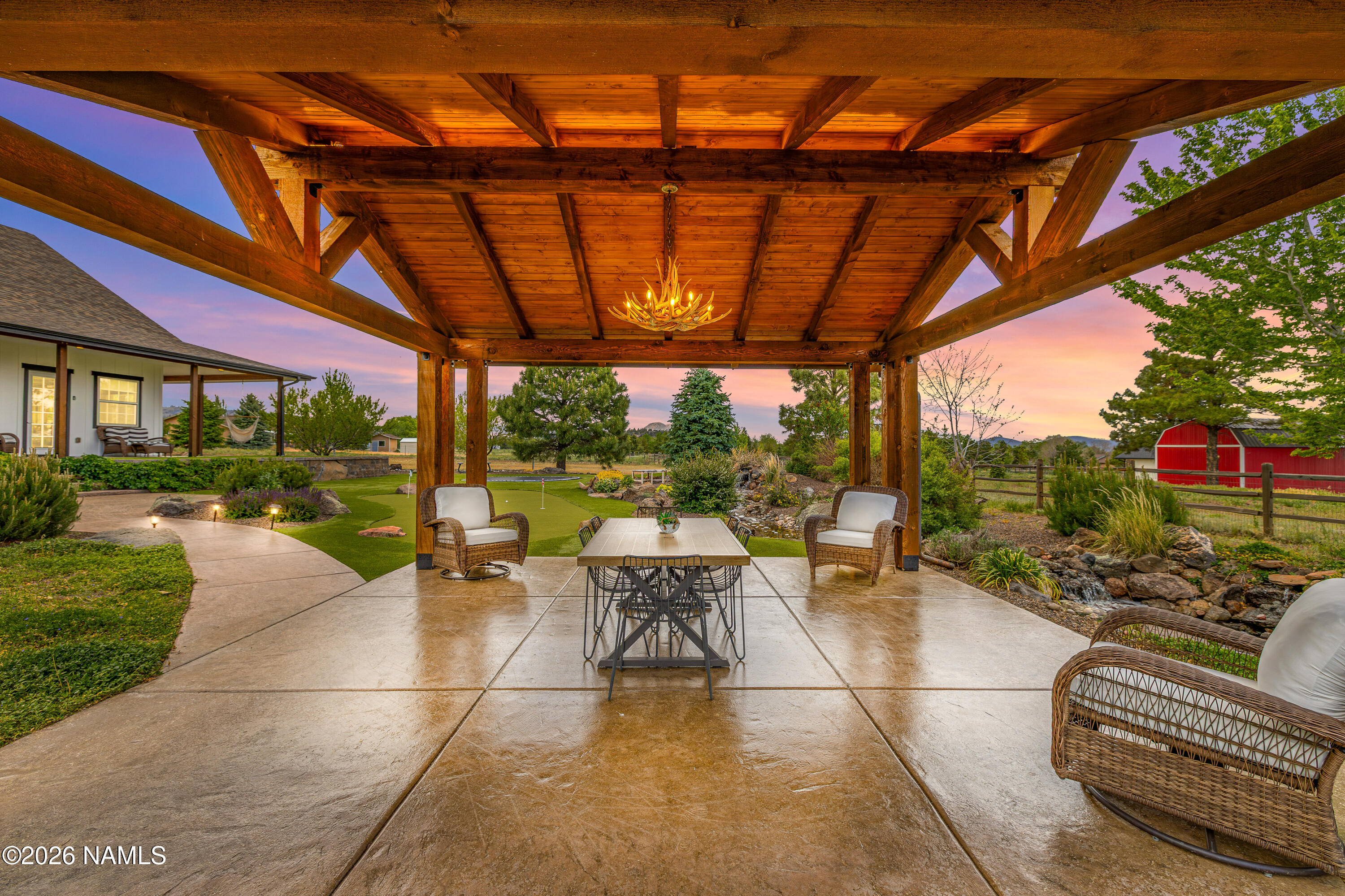 10833 Sage Road Flagstaff, AZ 86004 - Photo 34 of 45 a view of a patio with couches and table and chairs with wooden fence and plants