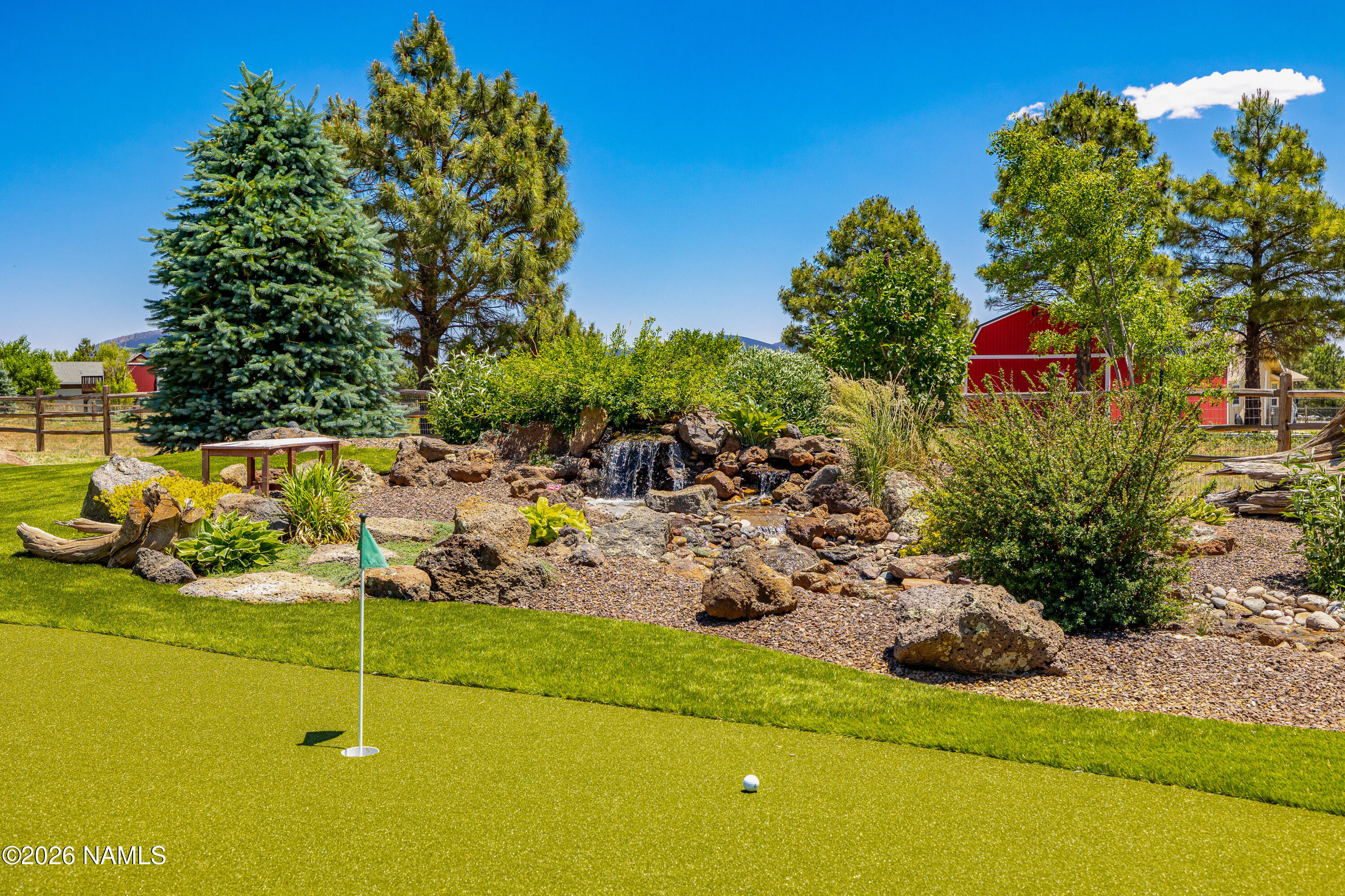 10833 Sage Road Flagstaff, AZ 86004 - Photo 39 of 45 a backyard of a house with lots of green space and fountain