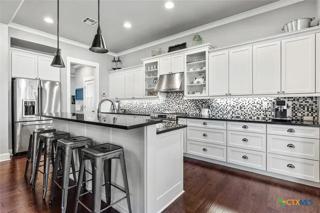 a kitchen with granite countertop white cabinets white appliances and granite counter tops