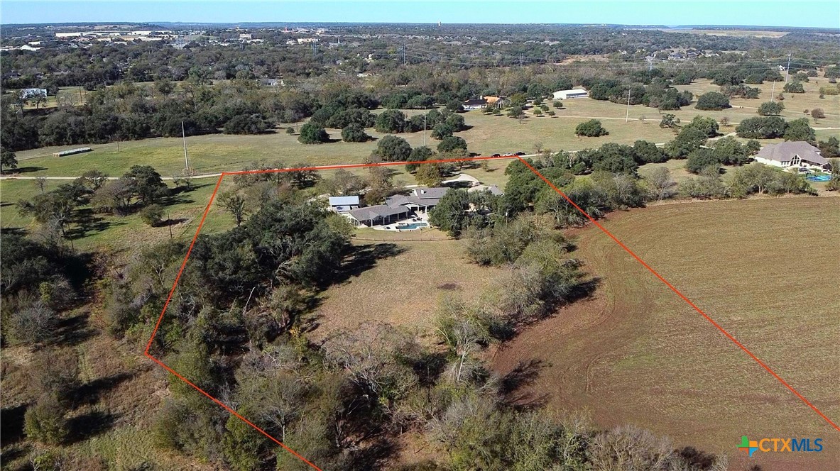 an aerial view of house with yard and mountain view in back