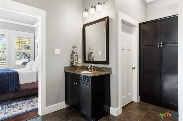 a bathroom with a granite countertop sink and a mirror