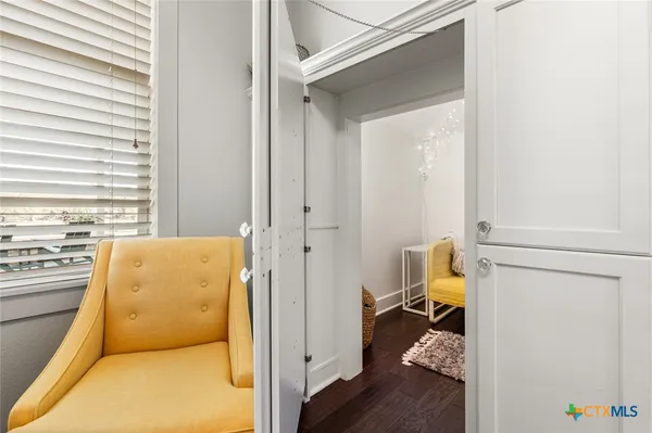 a view of a bedroom with a bed and wooden floor