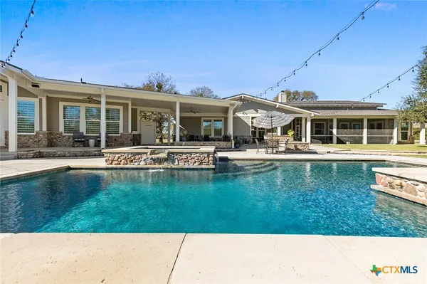 a front view of a house with swimming pool having outdoor seating