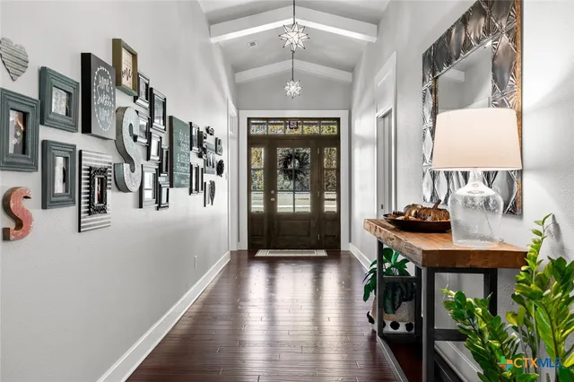 a view of a hallway with furniture and wooden floor