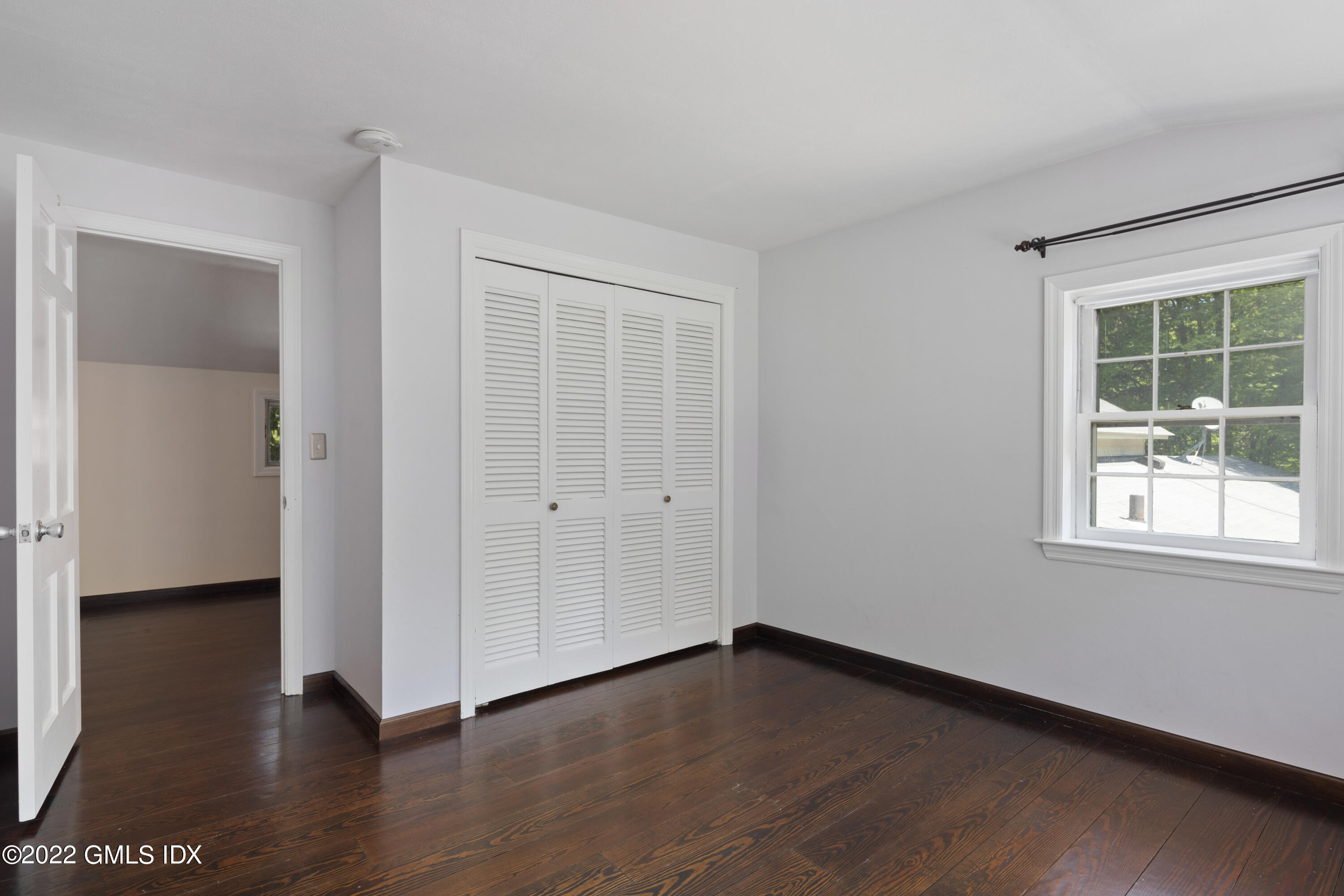 324 Haviland Road Stamford, CT 06903 - Photo 19 of 40 a view of an empty room with wooden floor and a window