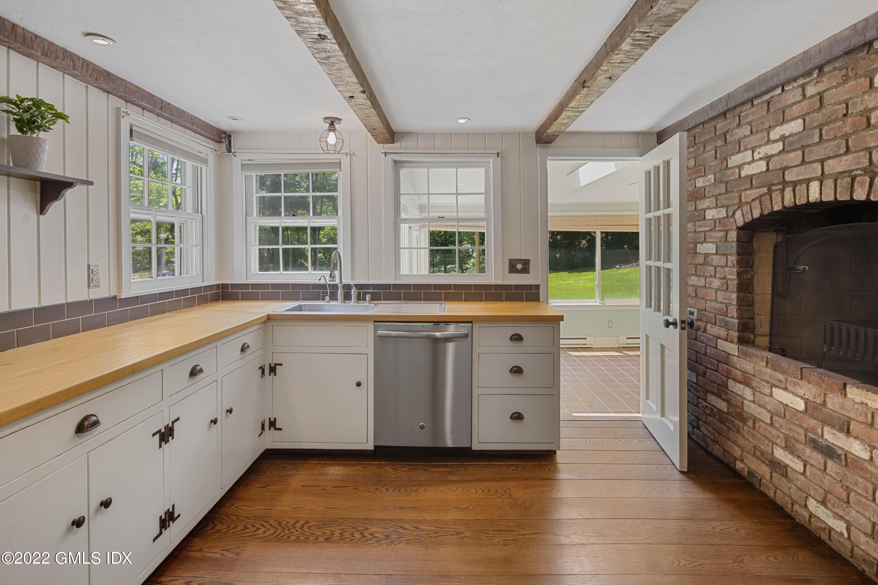 324 Haviland Road Stamford, CT 06903 - Photo 4 of 40 a large white kitchen with granite countertop a stove top oven a sink a dishwasher and a large window