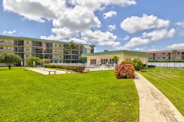 a view of a house with a big yard and potted plants