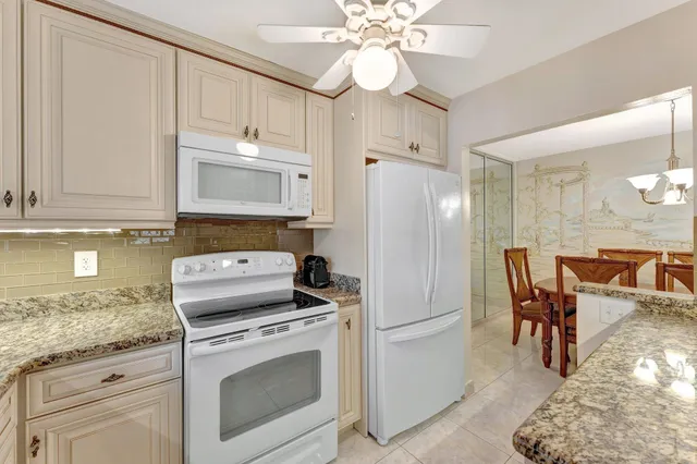 a kitchen with a white stove refrigerator and cabinets