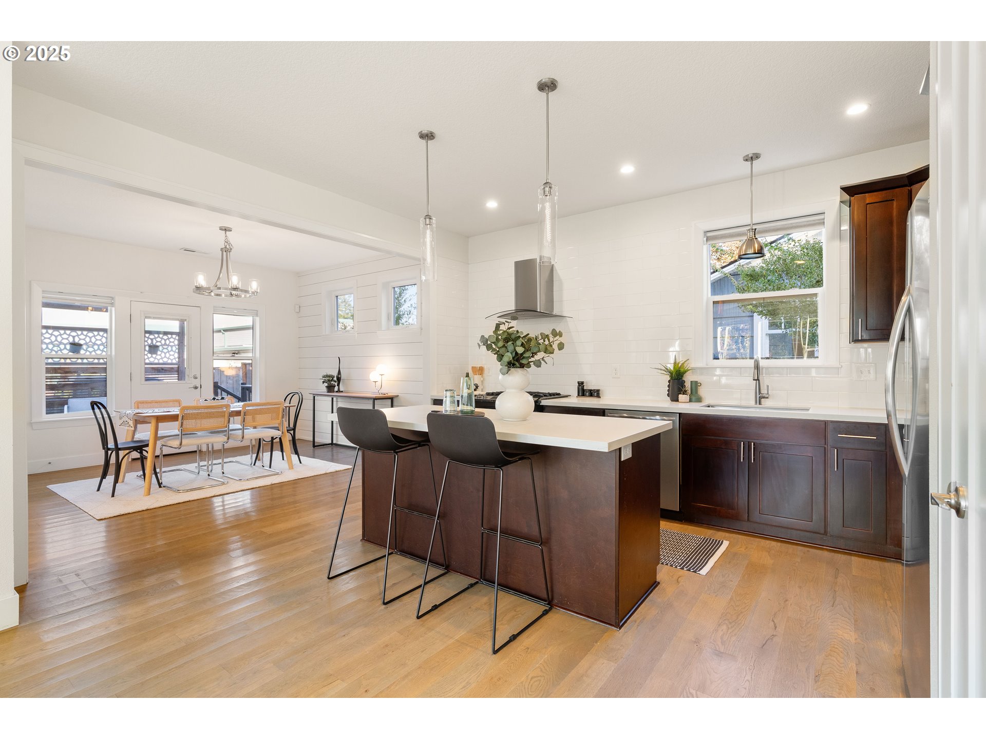4735 Southeast Bush Street Portland, OR 97206 - Photo 16 of 47 a living room with stainless steel appliances kitchen island granite countertop a sink dishwasher a dining table and chairs with wooden floor