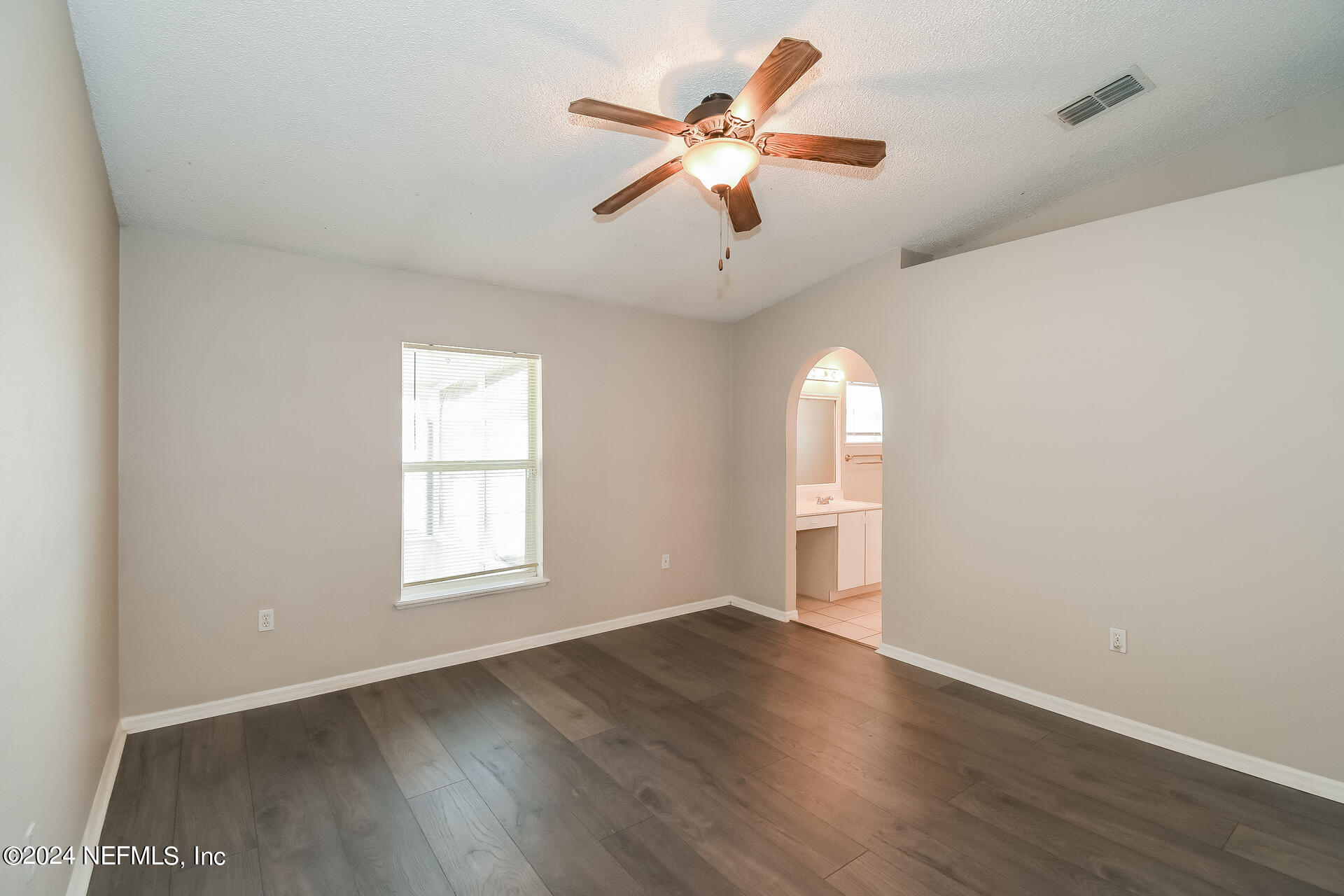 7351 Fox Grove Road Jacksonville, FL 32244 - Photo 10 of 17 an empty room with wooden floor fan and windows