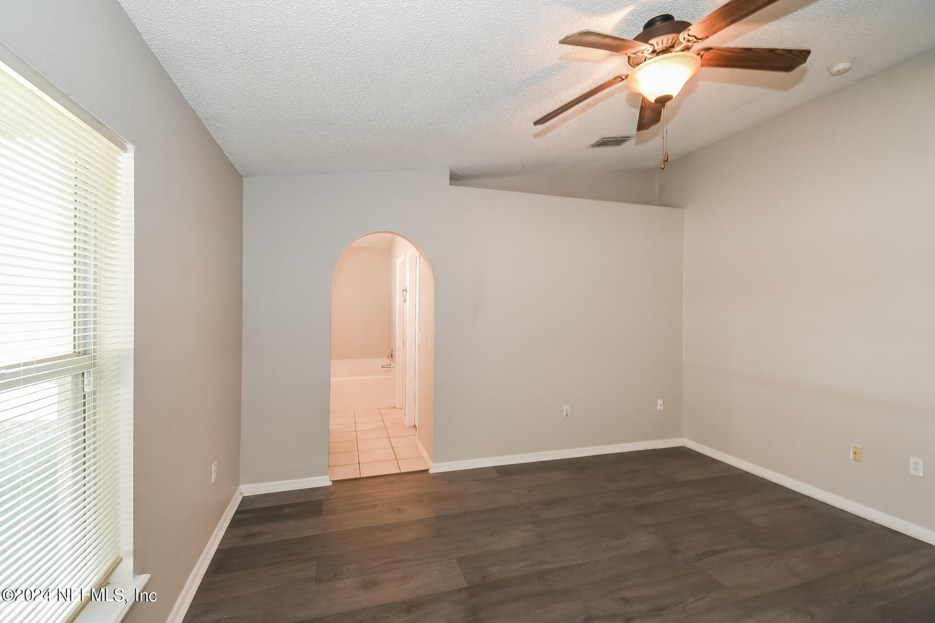 7351 Fox Grove Road Jacksonville, FL 32244 - Photo 11 of 17 an empty room with wooden floor fan and windows