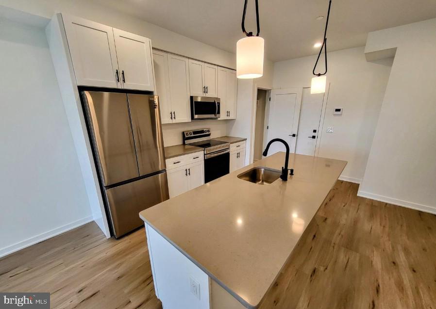 22 East Rittenhouse Street, Unit 3 Philadelphia, PA 19144 - Photo 4 of 13 a kitchen with stainless steel appliances a refrigerator a sink a stove a microwave and island
