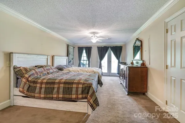 a bedroom with a large bed and a chandelier