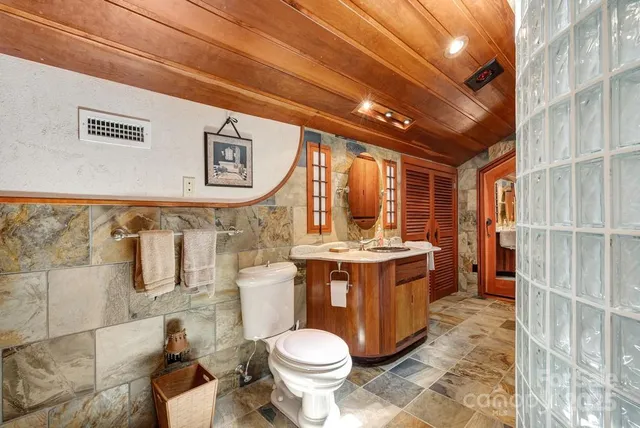 a spacious bedroom with a bed a chandelier and balcony