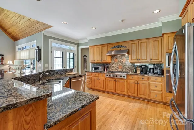 a kitchen with stainless steel appliances granite countertop a sink stove and refrigerator