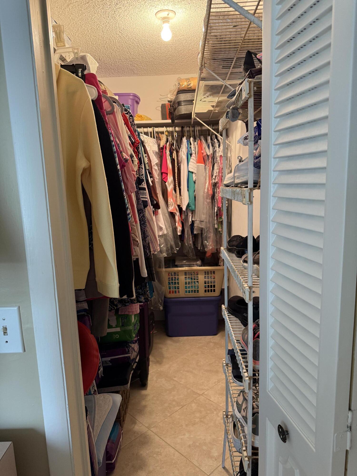 147 Burgandy Way Delray Beach, FL 33484 - Photo 11 of 14 a view of walk in closet with clothes and shoes