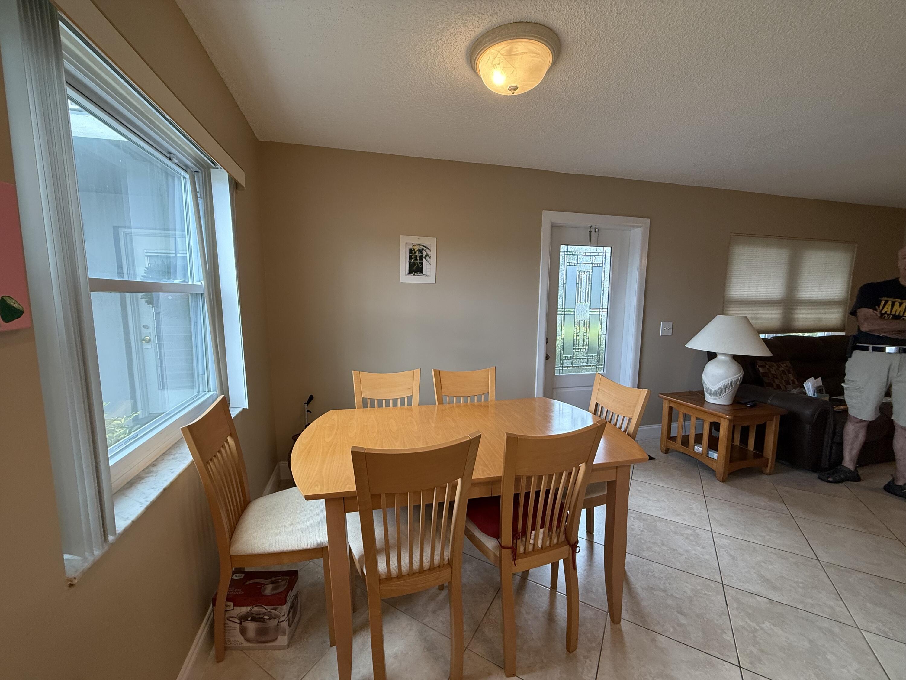 147 Burgandy Way Delray Beach, FL 33484 - Photo 6 of 14 a view of a dining room with furniture and chandelier