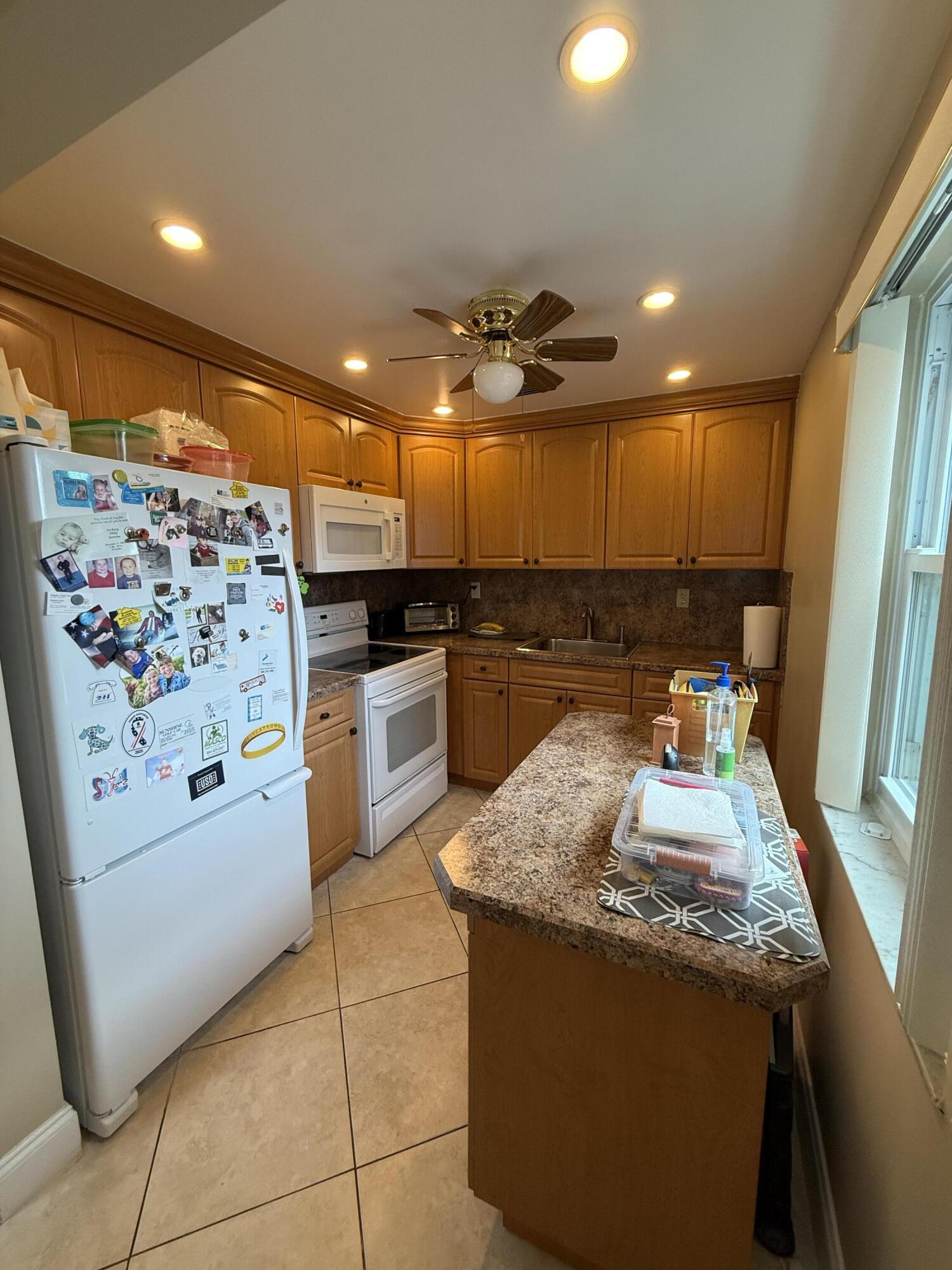 147 Burgandy Way Delray Beach, FL 33484 - Photo 8 of 14 a kitchen with granite countertop a sink and white cabinets