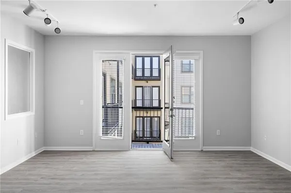 an empty room with wooden floor and windows