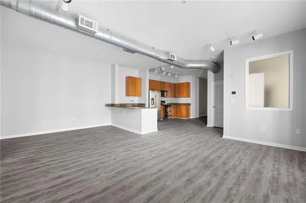 a view of empty room with wooden floor and windows