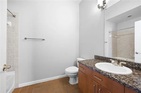 a bathroom with a granite countertop sink toilet and a mirror