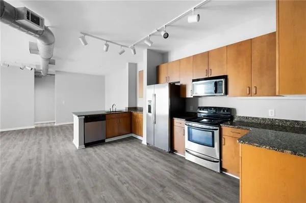 a large kitchen with cabinets wooden floor and stainless steel appliances