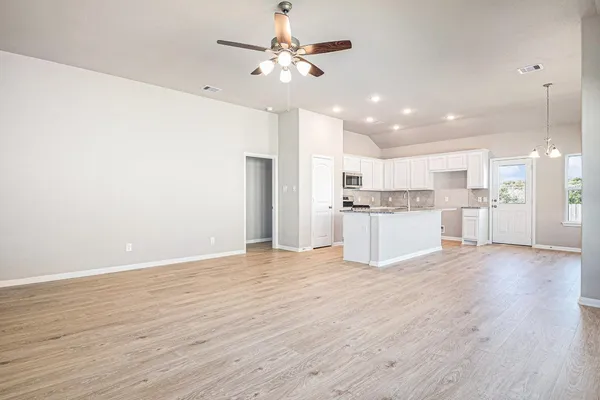 a large kitchen with cabinets wooden floor and stainless steel appliances