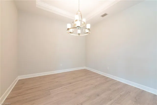 a view of a chandelier fan and hardwood floor