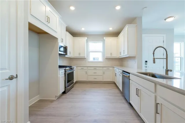a kitchen with a white cabinets stove and sink