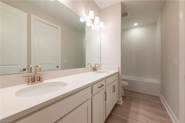 a bathroom with a double vanity sink and a mirror