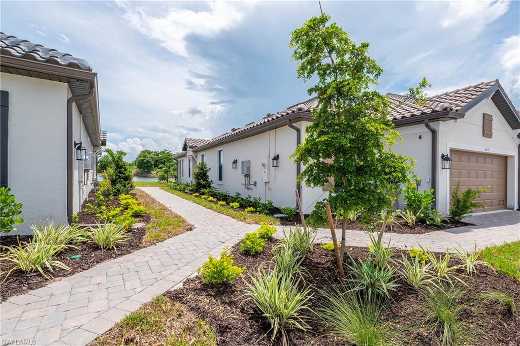 15633 Gavello Street Naples, FL 34114 - Photo 25 of 37 a vase of flowers sitting in a yard