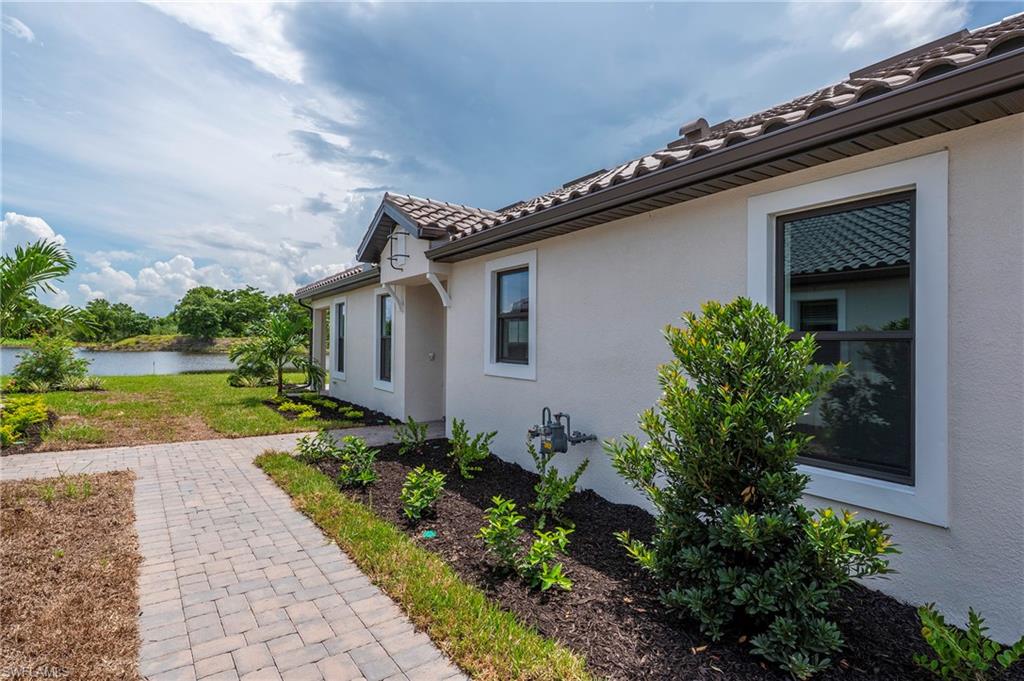 15633 Gavello Street Naples, FL 34114 - Photo 26 of 37 a front view of a house with garden
