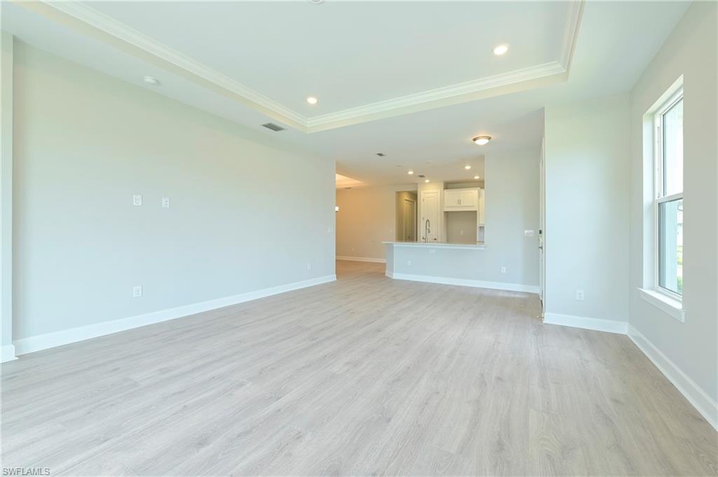 15633 Gavello Street Naples, FL 34114 - Photo 5 of 37 an empty room with wooden floor and windows