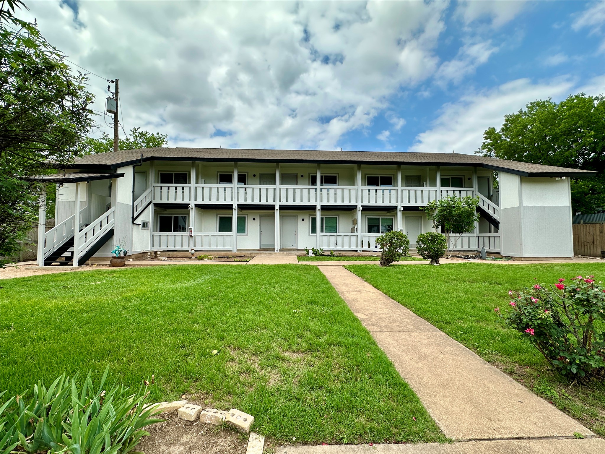 10810 Newmont Road, Unit 7 Austin, TX 78758 - Photo 13 of 13 The property features a two-story building with white exterior walls and dark roofing