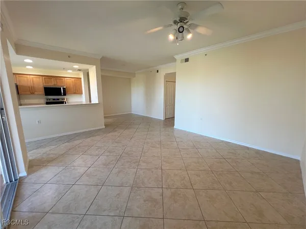 a view of a livingroom with an empty space and a ceiling fan