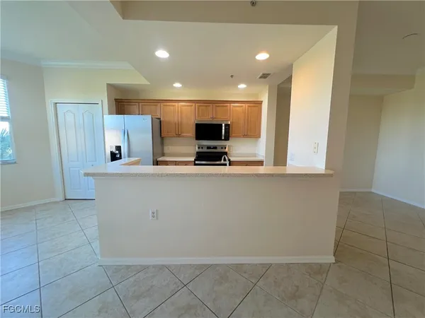 a large kitchen with stainless steel appliances a sink and a microwave