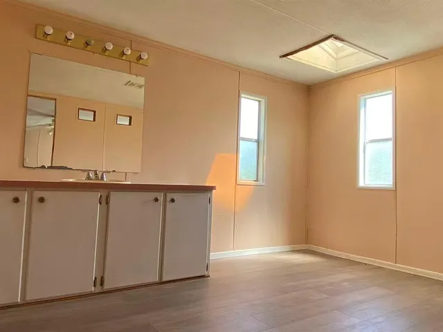 a view of a kitchen with wooden floor and cabinet