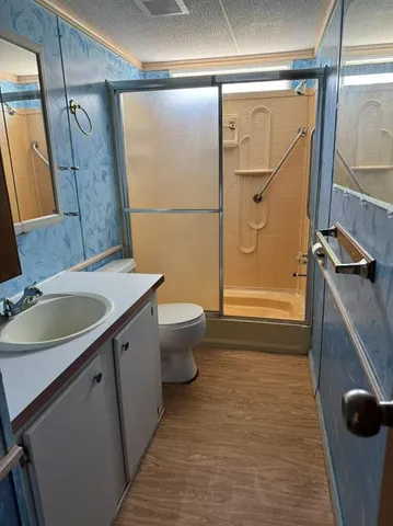 a bathroom with a granite countertop sink toilet and shower