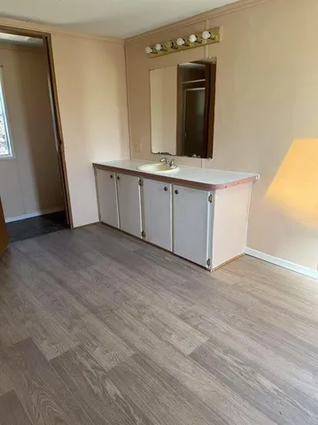a view of a kitchen with cabinets and wooden floor