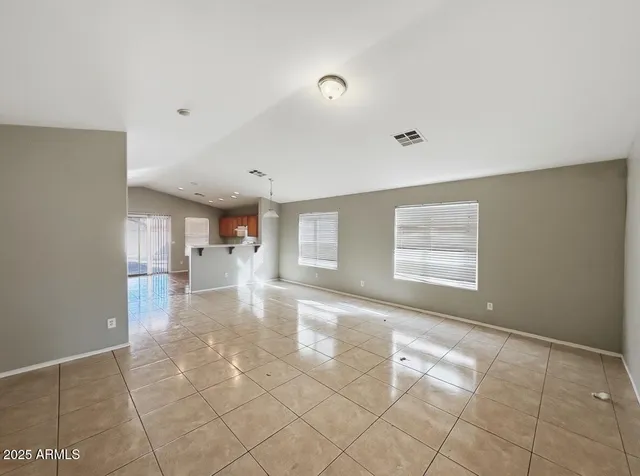a view of a livingroom with wooden floor and a kitchen space