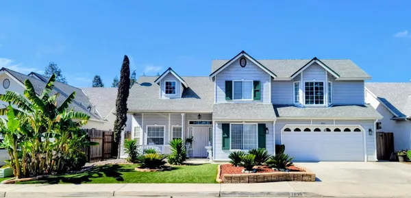 a front view of a house with a yard and potted plants
